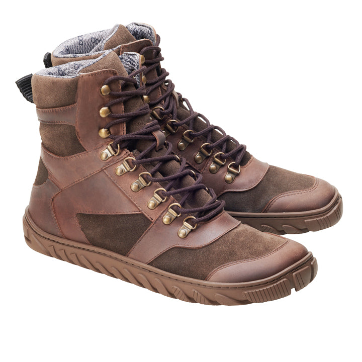 Die ZAQQ EXPLORER-Stiefel sind braune High-Top-Wanderschuhe mit dunkelbraunen Schnürsenkeln, metallischen Ösen und einer robusten Sohle. Sie verfügen über ein wasserdichtes Design und ein strukturiertes Stofffutter an der Oberseite und sind aus Leder und Wildleder gefertigt.