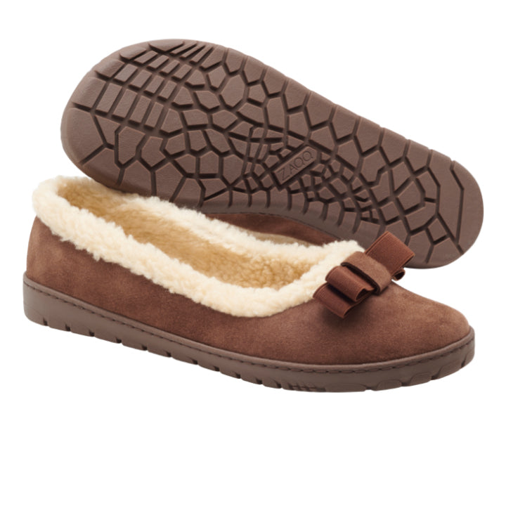 Die DAQIN Winter Brown Ballerinas von ZAQQ sind aus Veloursleder gefertigt und verfügen über ein flauschiges cremefarbenes Innenfutter mit einer dekorativen Schleife obenauf. Die Sohle ist mit einer rutschhemmenden Kautschuksohle ausgestattet, die mit einem strukturierten Profil für optimalen Halt sorgt.