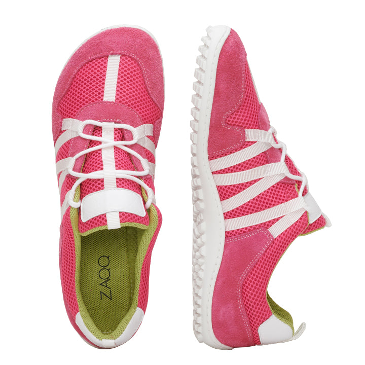 Ein Paar RIQ Pink Sportschuhe von ZAQQ, gefertigt aus Netzstoff und mit weißen Schnürsenkeln. Sie verfügen über grüne Innensohlen und ein markantes Sneakersohle-Design. Der linke Schuh ist von oben zu sehen, während der rechte Schuh von der Seite zu sehen ist.