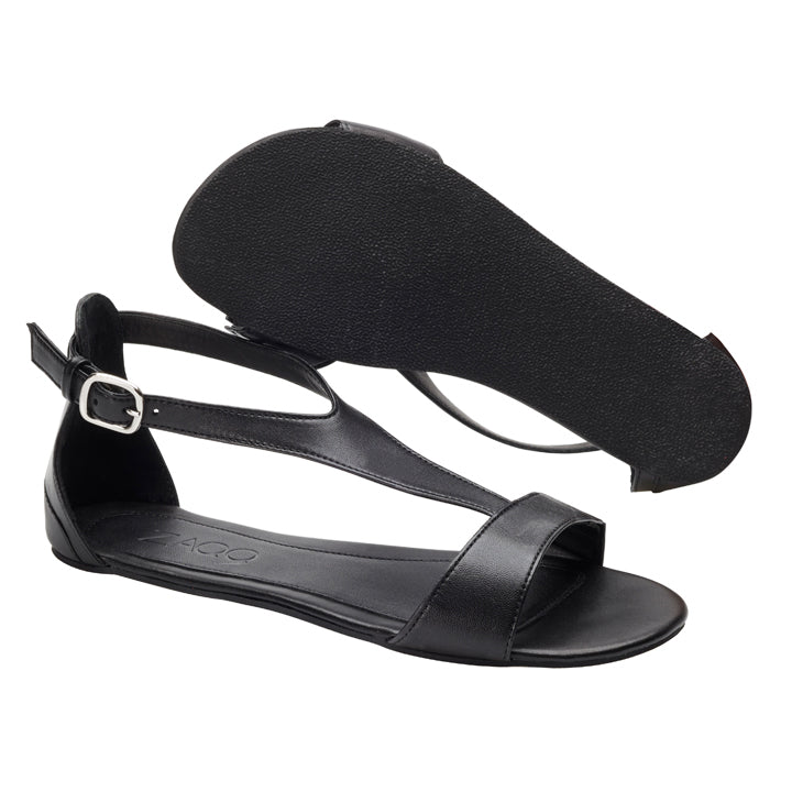 Ein Paar CLIQ Deep Black Sandalen von ZAQQ mit offenem Zehenbereich und flacher Sohle bietet außergewöhnlichen Tragekomfort. Diese Sandalen im Barfußsandalen-Stil haben verstellbare Knöchelriemen mit silbernen Schnallen. Eine Sandale steht aufrecht, während die andere die Sohle freigibt.