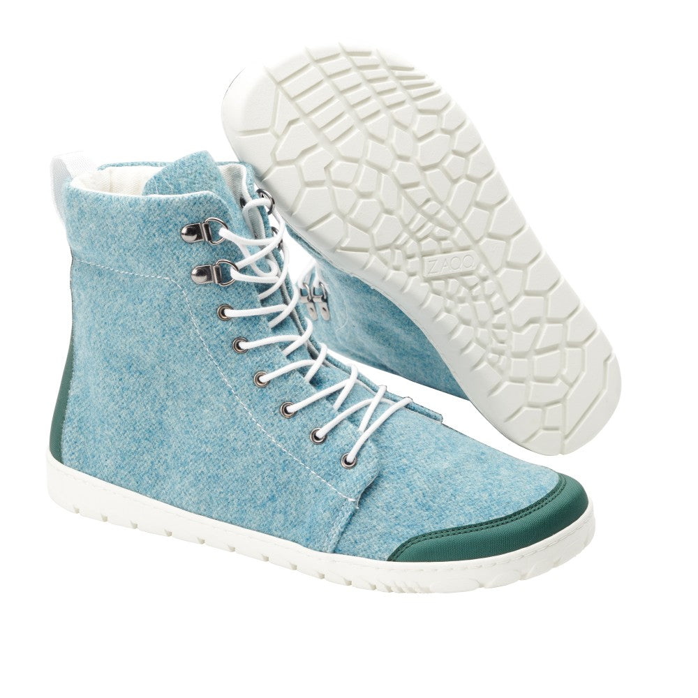 Wir präsentieren den QICE Green von ZAQQ: ein Paar hellblaue High-Top-Sneaker mit weißen Schnürsenkeln und Sohlen, einer Outdoor-Kautschuksohle mit sechseckigem Muster und stylischen grünen Akzenten an Zehen und Ferse für zusätzliches Flair.