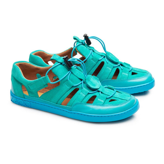 Die QLEAR Turquoise Sneaker von ZAQQ sind aus leuchtend türkisem Leder gefertigt, mit Cut-Out-Details und verstellbaren Schnürsenkeln. Sie bieten den Komfort von Barfußschuhen und bieten sowohl Seiten- als auch Frontansichten.