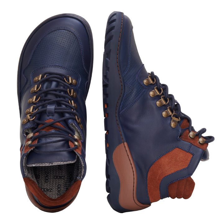 Wir präsentieren den VAQATION Cognac Waterproof von ZAQQ, ein Paar Wanderstiefel in einem satten Blauton mit stilvollen braunen Akzenten. Diese Stiefel verfügen über robuste Schnürsenkel, die durch Metallösen gefädelt sind und so für Langlebigkeit sorgen. Die außergewöhnliche Traktion wird durch die strukturierte ZAQQ TERRA Sohle gewährleistet. Ein Stiefel ist aufrecht abgebildet, während der andere auf der Seite liegt, wodurch das Innenfutter dieses vielseitigen Outdoor-Schuhs hervorgehoben wird.