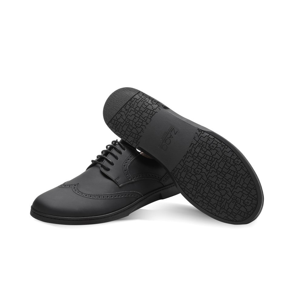 Wir präsentieren den ZAQQ BRIQ Brogue Vegan Black, ein elegantes Paar schwarzer Abendschuhe mit exquisiten, detaillierten Nähten und einem geometrischen Muster auf der strukturierten Sohle. Diese veganen Herrenschuhe haben eine rutschhemmende Sohle für verbesserten Halt und Stil und sind damit perfekt für jeden Anlass.