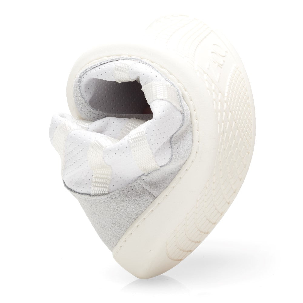 Der SPARQ High White Schuh von ZAQQ aus Premium Nappaleder ist gebogen, um seine Flexibilität zu betonen. Dieser weiße Barfußschuh verfügt über eine strukturierte Sohle und ein weiches Obermaterial und zeigt seinen Komfort und seine Anpassungsfähigkeit.